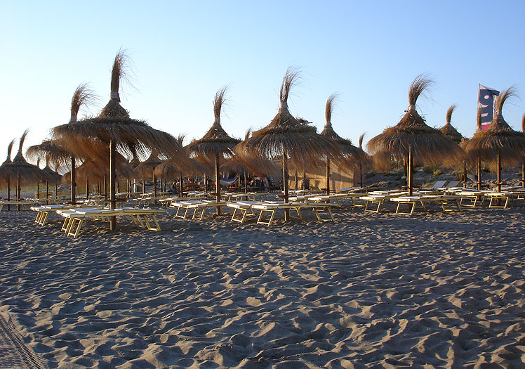 Spiaggia attrezzata del Fuorirotta Beach Club con ombrelloni e gazebo etnici