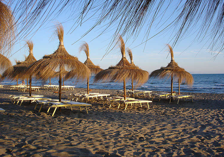 Lettini e ombrelloni vista mare sulla spiaggia del Fuorirotta Beach Club