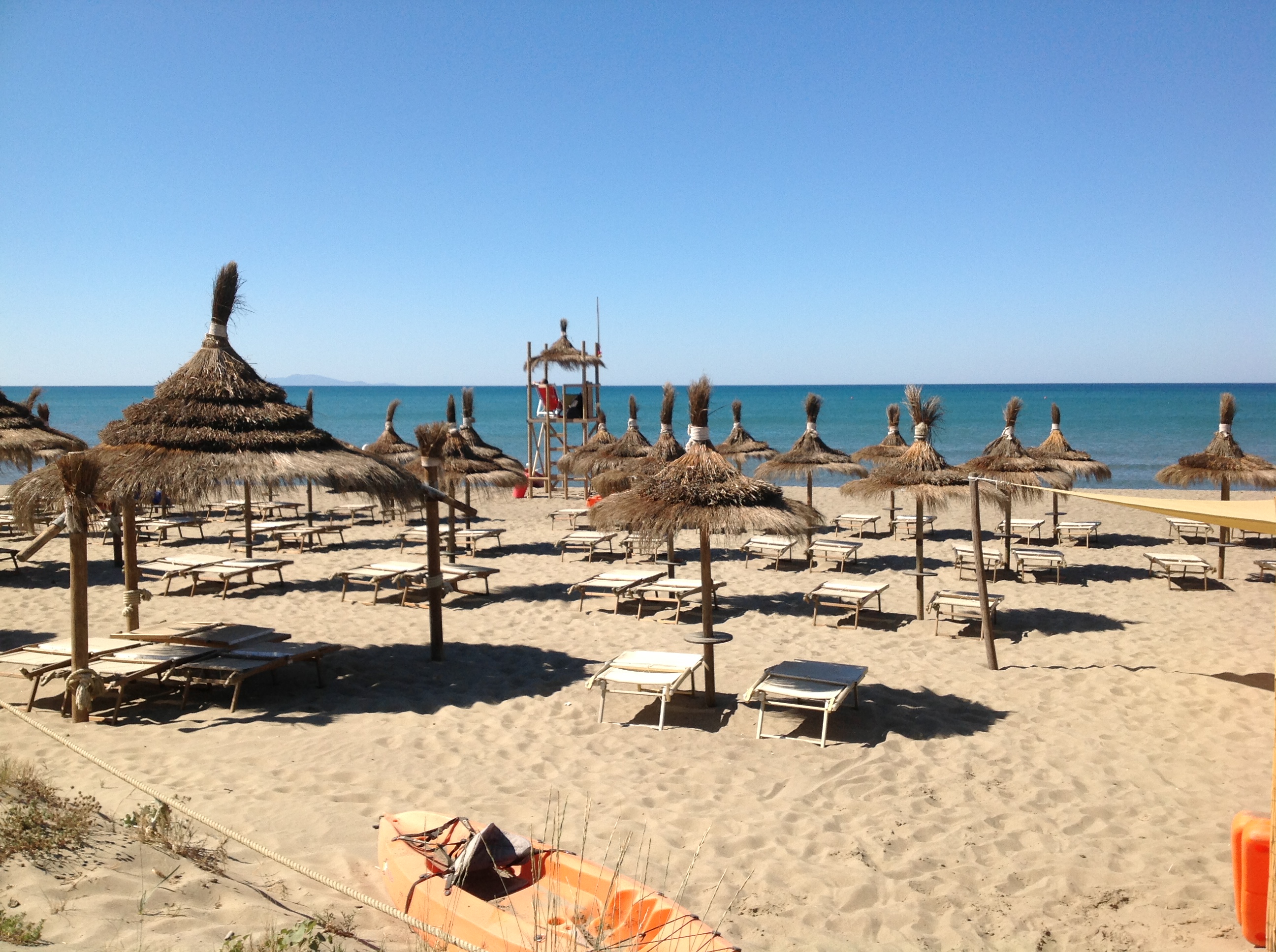 Spiaggia del Fuorirotta Beach Club con ombrelloni e mare cristallino