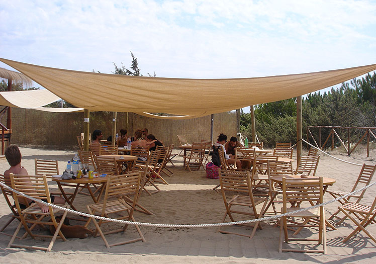 Clienti del Fuorirotta Beach Club seduti ai tavoli sotto il tendone del beach bar